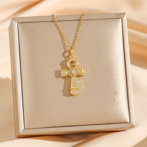 Golden Ankh cross necklace with sparkling zircons displayed on elegant satin fabric