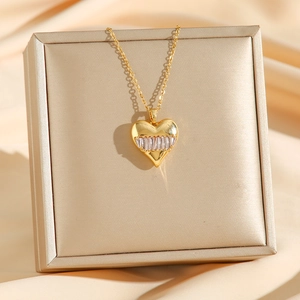 Collier à pendentif cœur doré avec zircons baguette sur fond de soie élégant