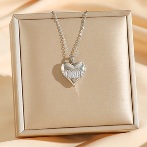 Collier pendentif cœur en zircon étincelant présenté sur un tissu satiné champagne