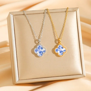 Blue floral clover pendants in gold and silver finish on champagne silk backdrop