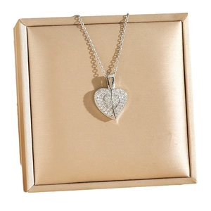 Collier avec pendentif cœur serti de strass présenté sur une boîte à bijoux en satin