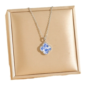 Silver titanium clover necklace with blue floral porcelain pattern on jewelry box