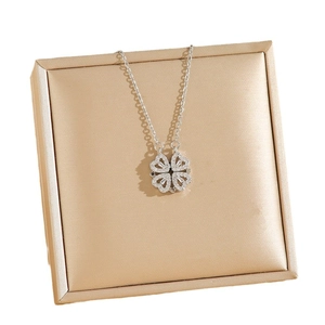 Collier trèfle cœur argenté orné de diamants scintillants sur support champagne