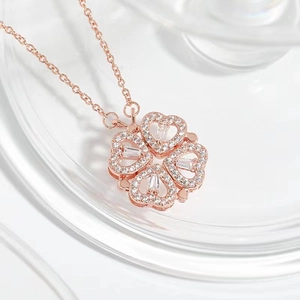 Détail macro du pendentif trèfle en or rose avec cristaux pavés étincelants et pierres