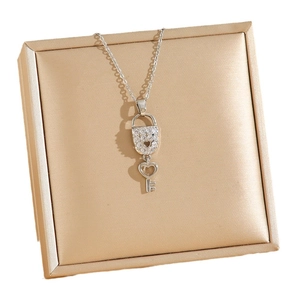 Collier argenté avec cadenas et clé en zircons sur un présentoir à bijoux