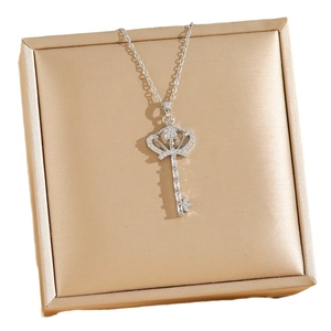 Collier clé couronne argenté serti de zircons sur un coffret à bijoux de luxe