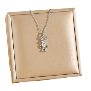 Collana con orsetto in argento e micro-diamanti su un lussuoso portagioie in raso champagne