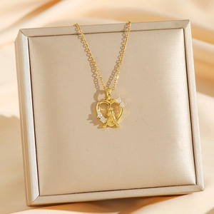 Collier cœur doré avec pendentif Tour Eiffel et zircons sur fond de satin de luxe