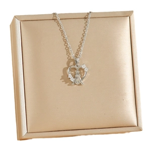 Collier cœur argenté avec pendentif Tour Eiffel et zircons sur une boîte à bijoux