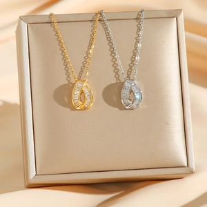 Elegant gold and silver teardrop necklaces with micro-paved cubic zirconia on silk cloth