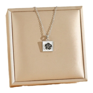 Silver titanium necklace with black rose pendant on champagne gold jewelry gift box