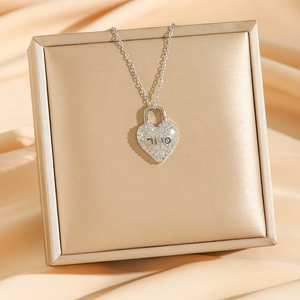 Silver heart locket necklace with pavé zircon stones on luxury champagne silk display