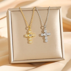 Colliers croix en or et argent avec micro-diamants sur un fond de soie couleur champagne