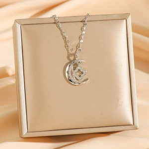 Silver crescent moon necklace with four-leaf clover pendant and sparkling zircon stones