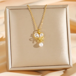 Élégant collier doré avec pendentif papillon en zircon et perle sur boîte à bijoux