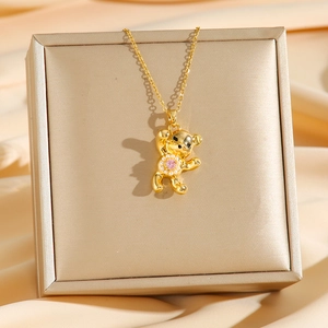 Collier pendentif ours doré mignon avec perle et pierre précieuse sur un écrin