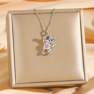 Collier ours argenté avec pierre rose et perles sur fond en satin élégant