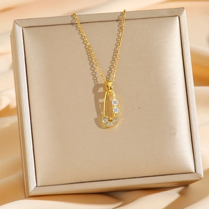 Gold paperclip necklace with sparkling cubic zirconia on elegant champagne silk