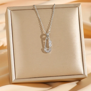 Silver titanium steel safety pin necklace with pavé cubic zirconia on satin backdrop