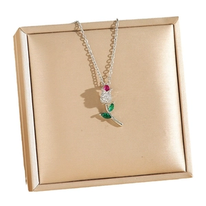 Elegant rose necklace with zircon stones on champagne jewelry box background