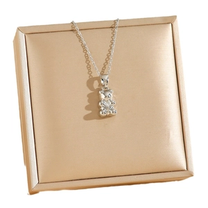 Polished silver bear pendant necklace on premium jewelry box with a minimalist chain
