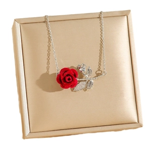 Collier élégant avec rose rouge en velours et feuille de zircon sur support