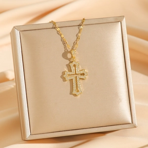 Retro gold cross necklace with zircon crystals on luxury champagne satin background