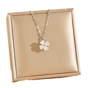 Elegant silver clover necklace with pink opal heart petals on a champagne jewelry box