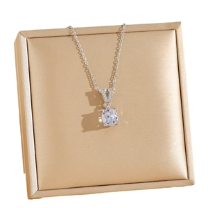 Silver V-shape zircon necklace with round brilliant pendant on gold display pad