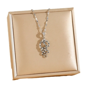 Silver snake pendant necklace featuring black zircons and red eyes on gold box