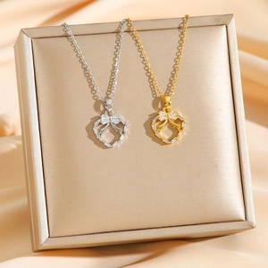 Collier en titane avec pendentif cœur et nœud en zircone, finitions dorée et argentée