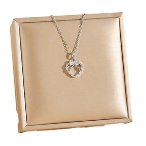 Collier en acier titane avec pendentif cœur nœud et zircon sur boîte à bijoux