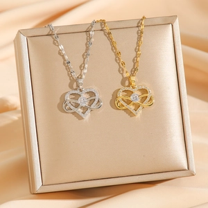 Herzanhänger mit Unendlichkeitssymbol und Zirkonia in Gold und Silber auf Seidenstoff