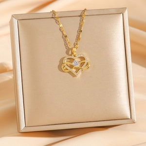 Goldene Herz-Infinity-Halskette mit Zirkonia auf champagnerfarbenem Seidenhintergrund