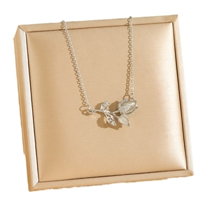 Collier tulipe en argent avec pétales d'opale et diamants sur un écrin de luxe