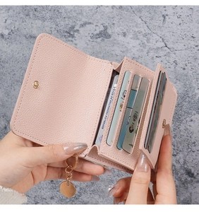Detailed interior of a pink leather card wallet showing vertical card slots and gold snap