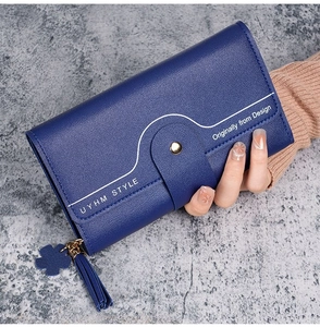 Navy blue long wallet with lychee grain texture featuring wavy flap and clover tassel detail