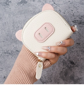 Close-up of compact pig-shaped accordion card holder with textured litchi pattern leather