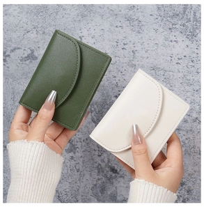 Close-up of pebble grain PU leather texture on minimalist small wallets in green and beige