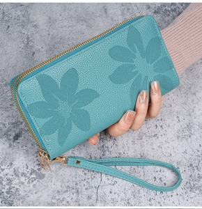 Vue détaillée du portefeuille long bleu avec gaufrage floral et double fermeture éclair