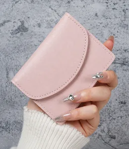 Close-up of a pink faux leather card holder wallet showing fine pebble grain texture