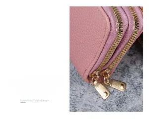 Close-up of pink litchi grain leather card holder with dual golden metal zippers