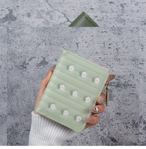 Detailed embroidery of small white daisies on a light green PU leather short wallet