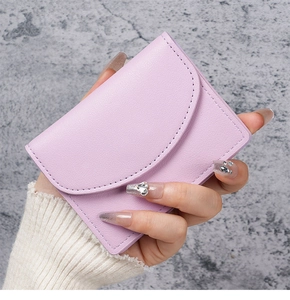 Close-up of lilac purple textured PU leather card holder held in hand against stone