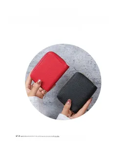 Detail of red and black lychee grain leather card holder with secure metal zipper closure