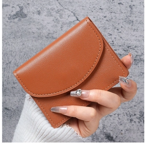 Close-up of a brown pebble-textured PU leather card holder with a snap button closure