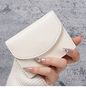 Close-up of a compact beige PU leather card holder with lychee texture and stitching