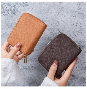 Detail of double-layer card holder in lychee grain PU leather with golden dual zippers