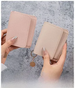 Litchi texture leather card holder with gold metal ring charm held by a hand