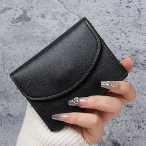 Close-up of black litchi texture PU leather mini wallet with curved flap and neat stitching